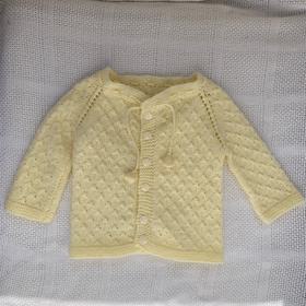 Hand knit cardigan with belled strings.
